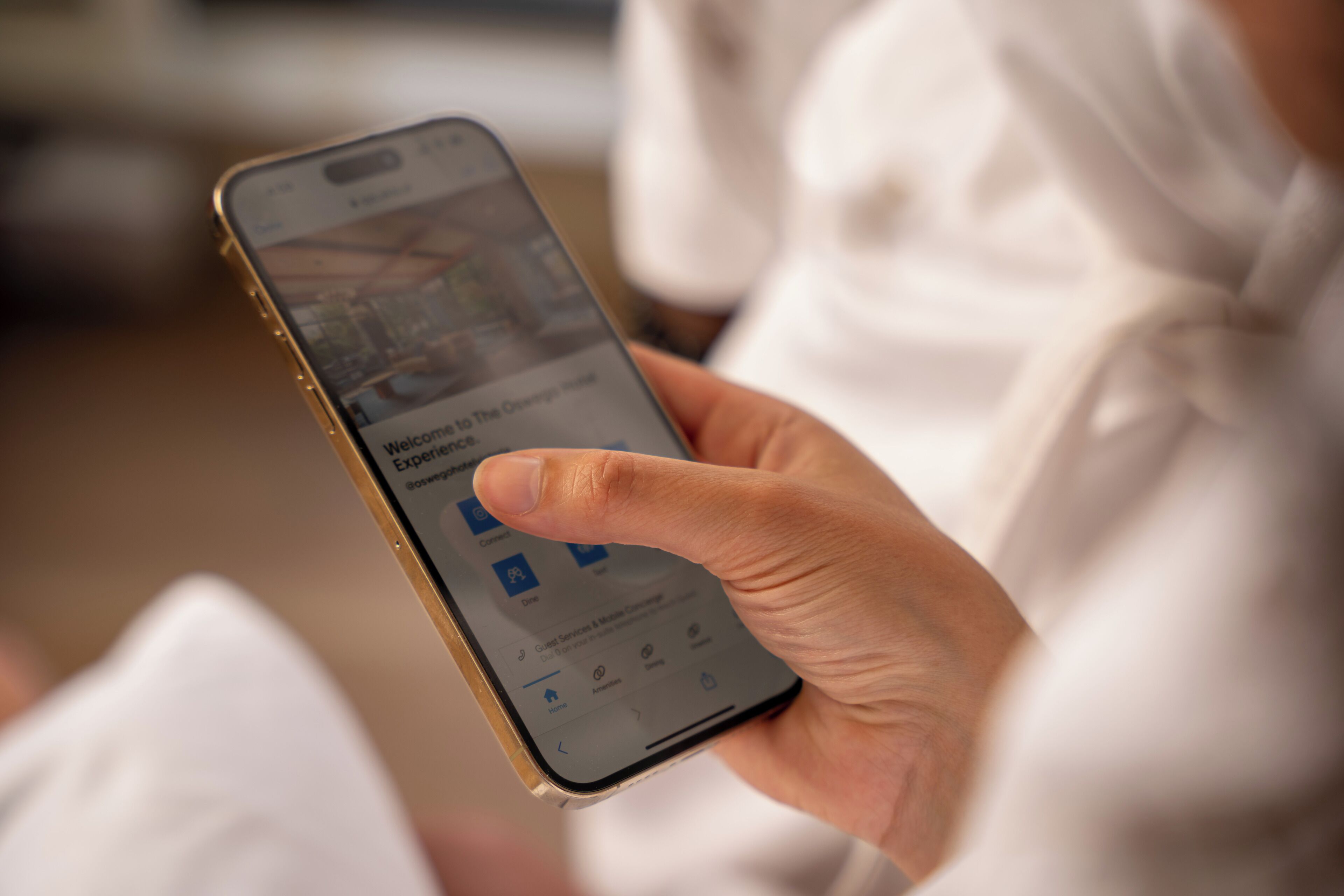 A person holding a smartphone displaying a hotel booking interface.