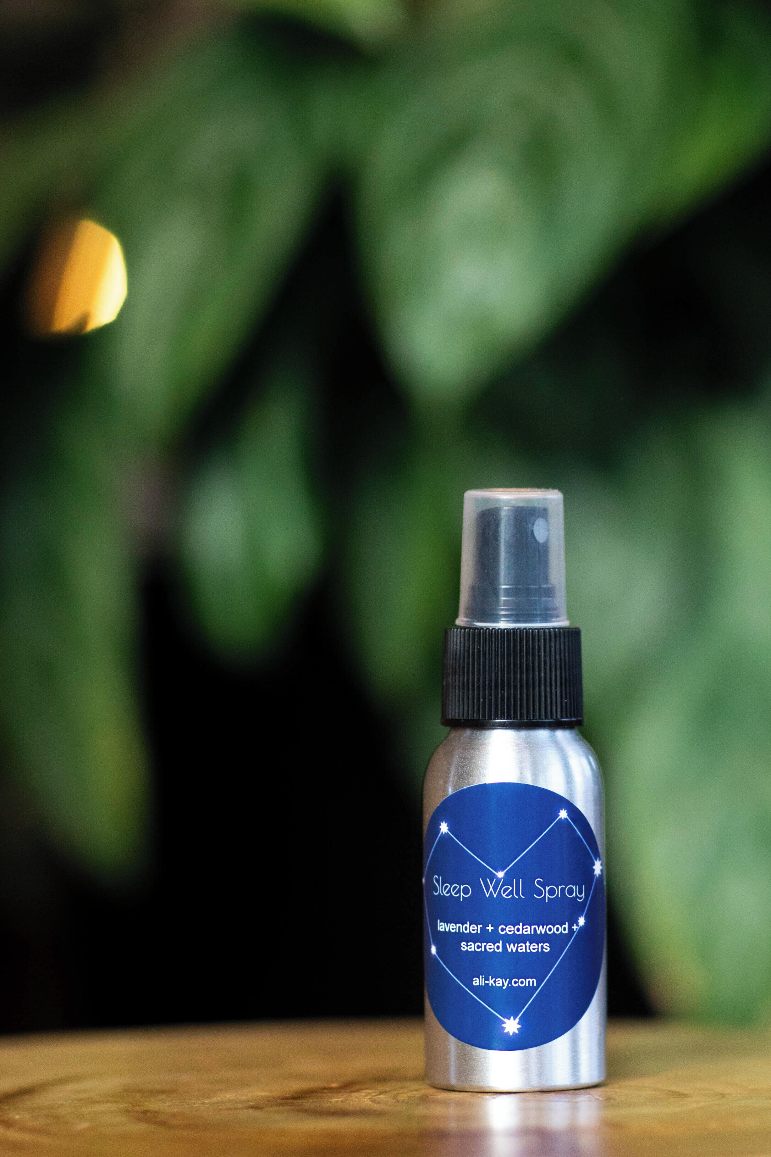 A bottle of Sleep Well Spray with a label indicating it contains lavender, cedarwood, and sacred waters.