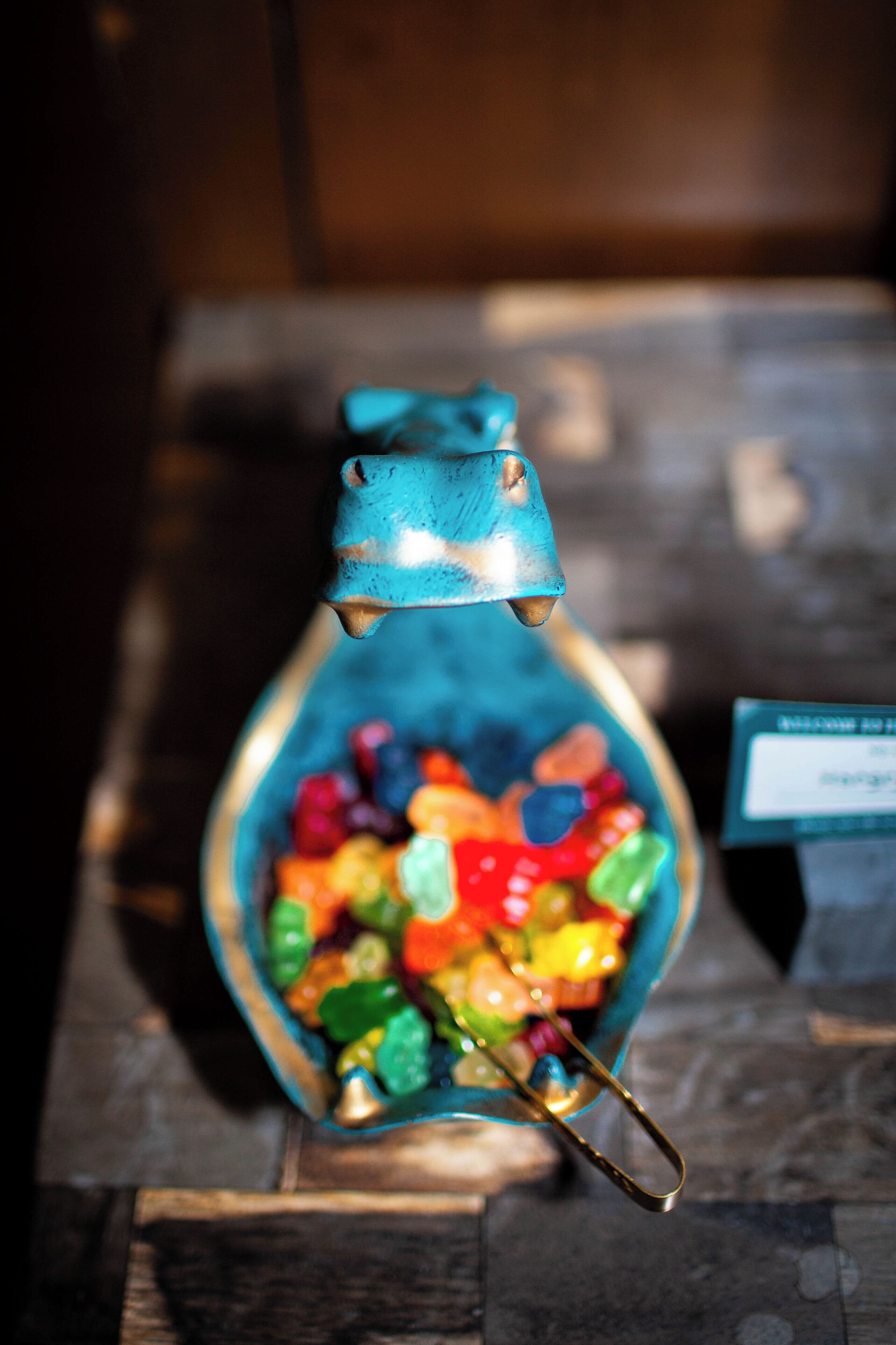 Un récipient bleu en forme de bouteille, rempli de bonbons de couleurs vives.