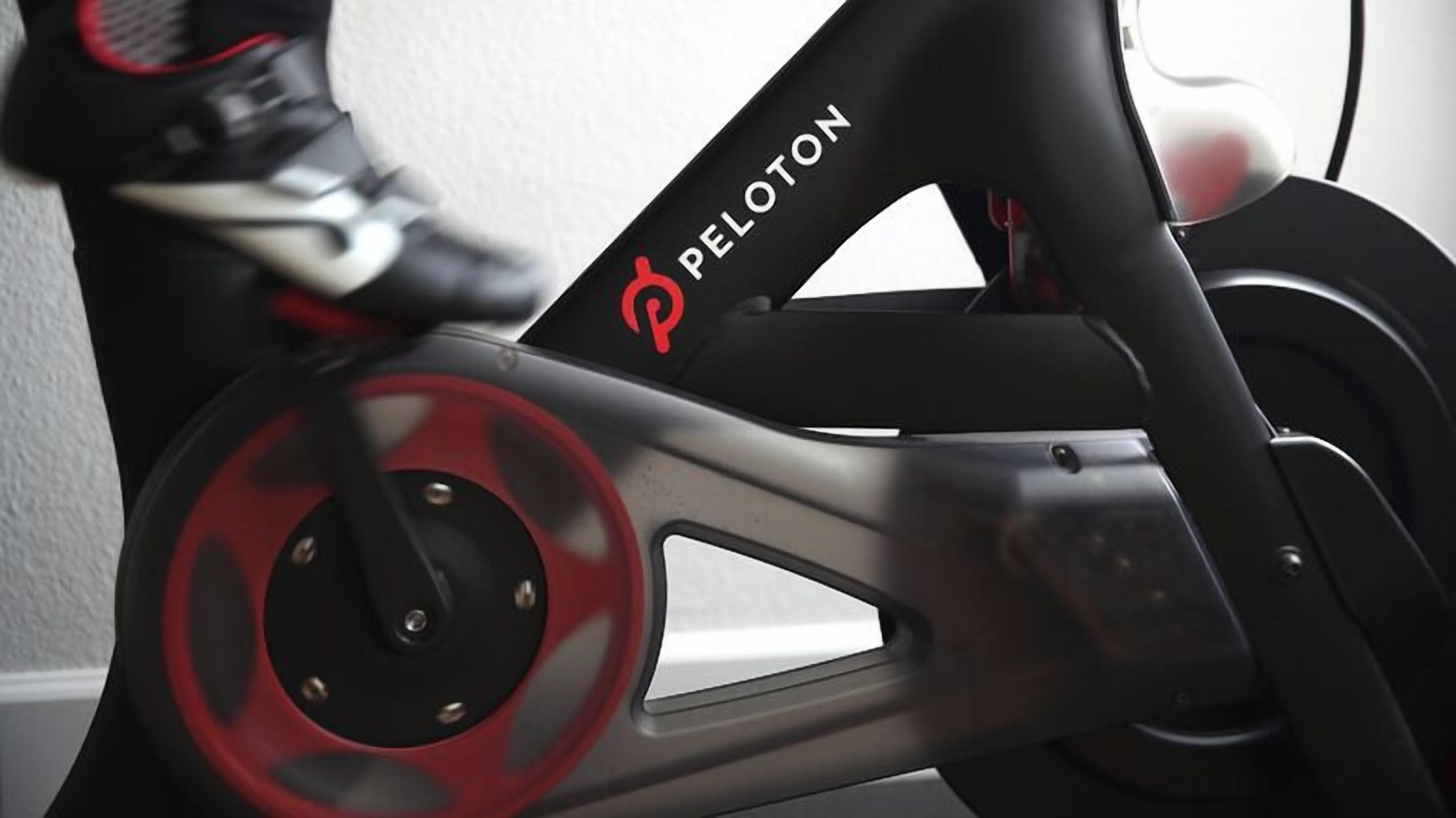 Un vélo d'appartement Peloton aux couleurs noir et rouge.