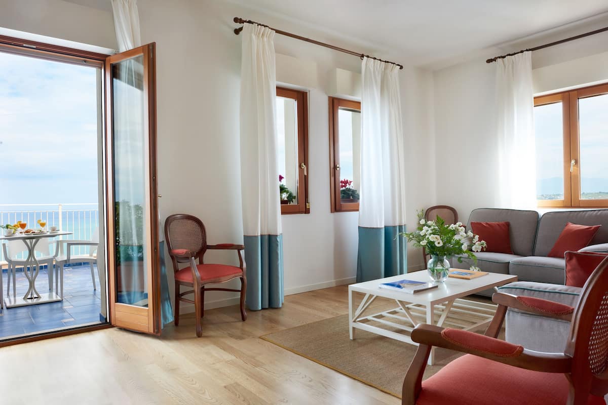 Un salón amplio con balcón, un sofá, una mesa de centro y una silla.