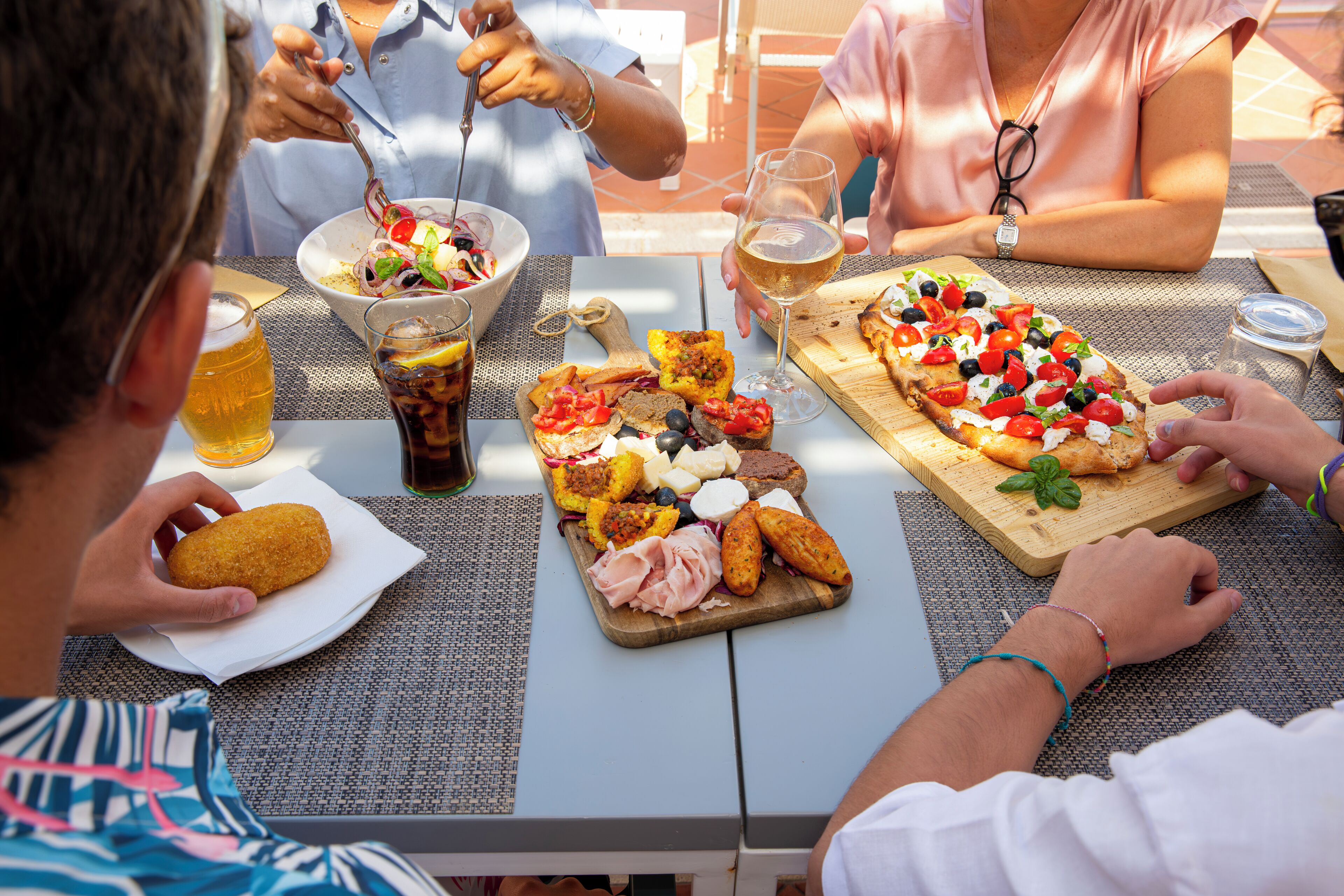 A dining table with various food items and drinks.