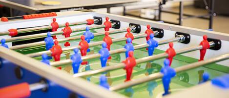 Una mesa de fútbolín con figuras de jugadores rojos y azules.