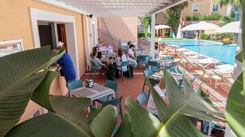 A poolside area with outdoor seating and a pool.