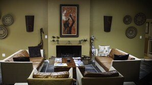 Ein Wohnzimmer mit Kamin, zwei Sofas, einem Couchtisch und dekorativen Tellern an der Wand.