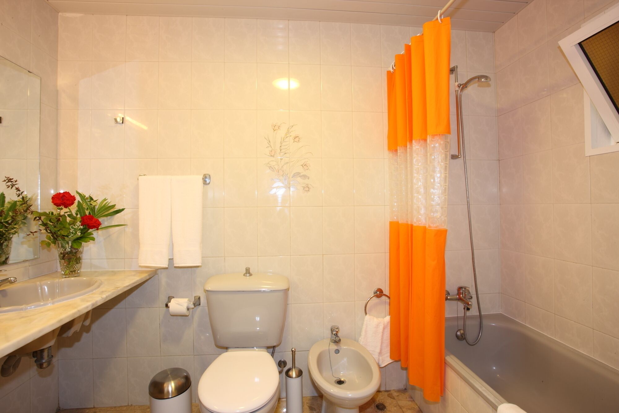 A bathroom with a toilet, bidet, sink, and bathtub.