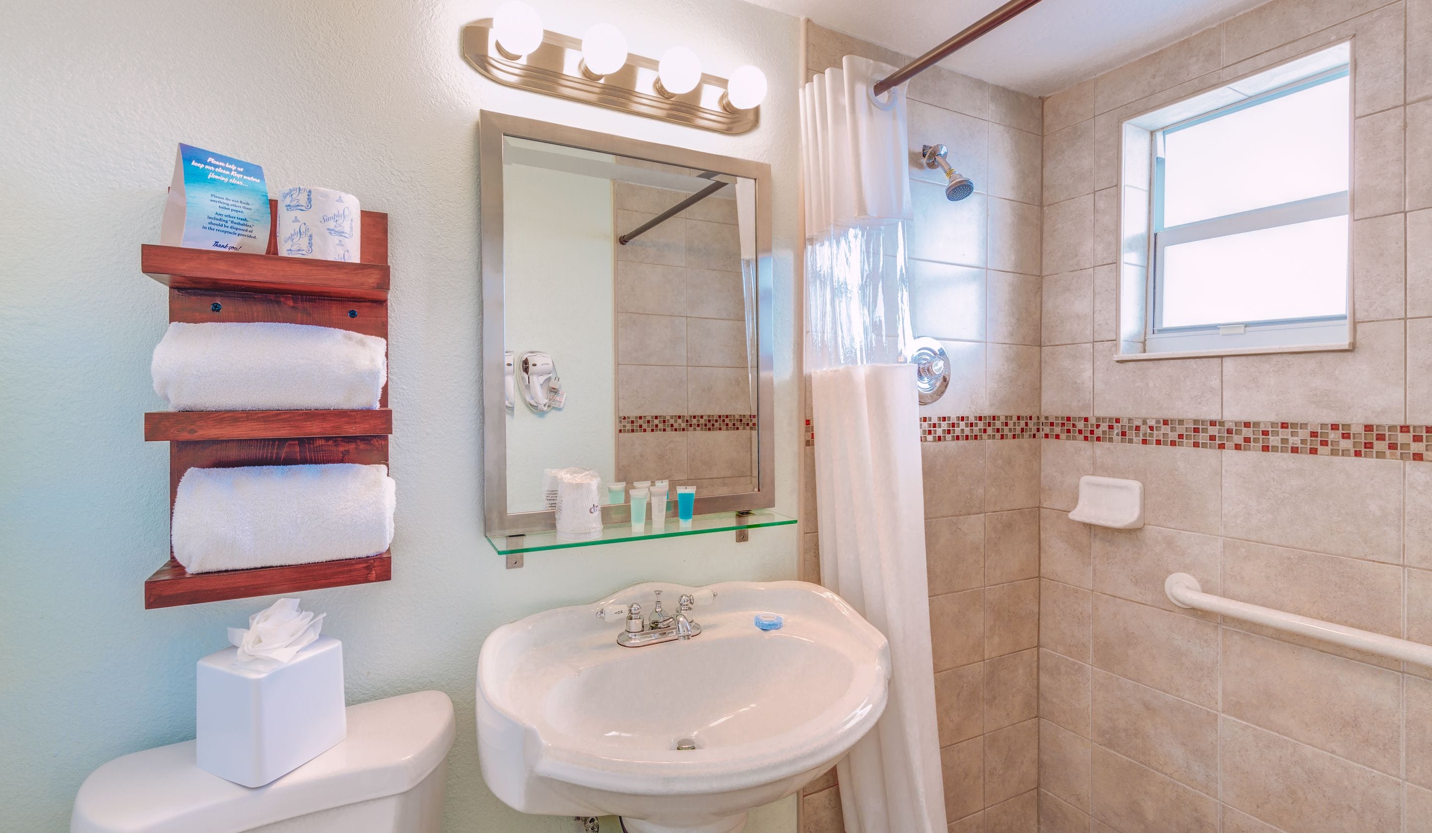 A bathroom with a sink, mirror, towel rack, and shower.