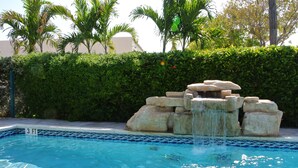 A swimming pool with a rock waterfall feature and a 3 ft depth marker. - Creekside Inn (Tavernier)
