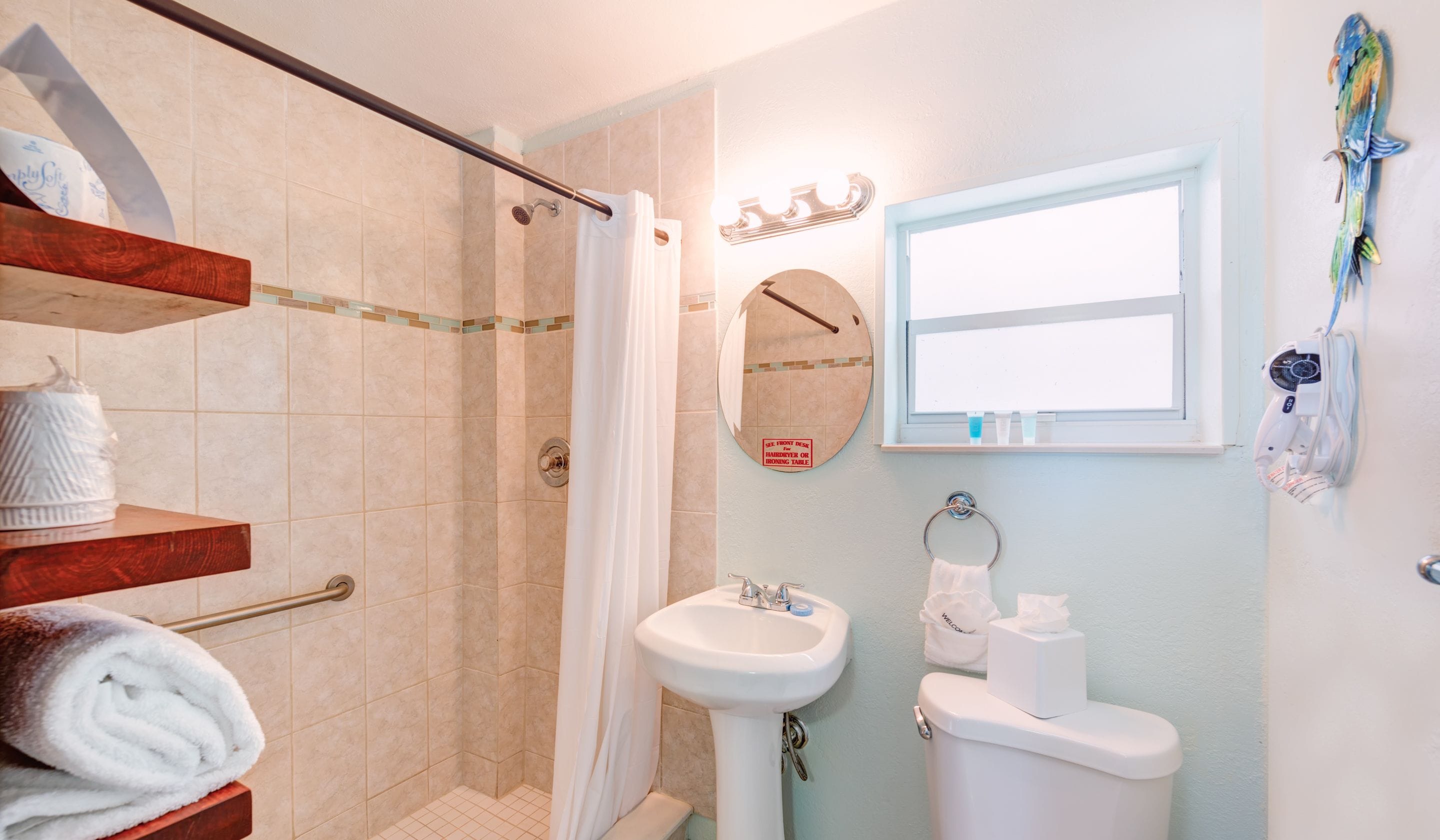 A bathroom with a shower, a sink, a toilet, and a mirror.