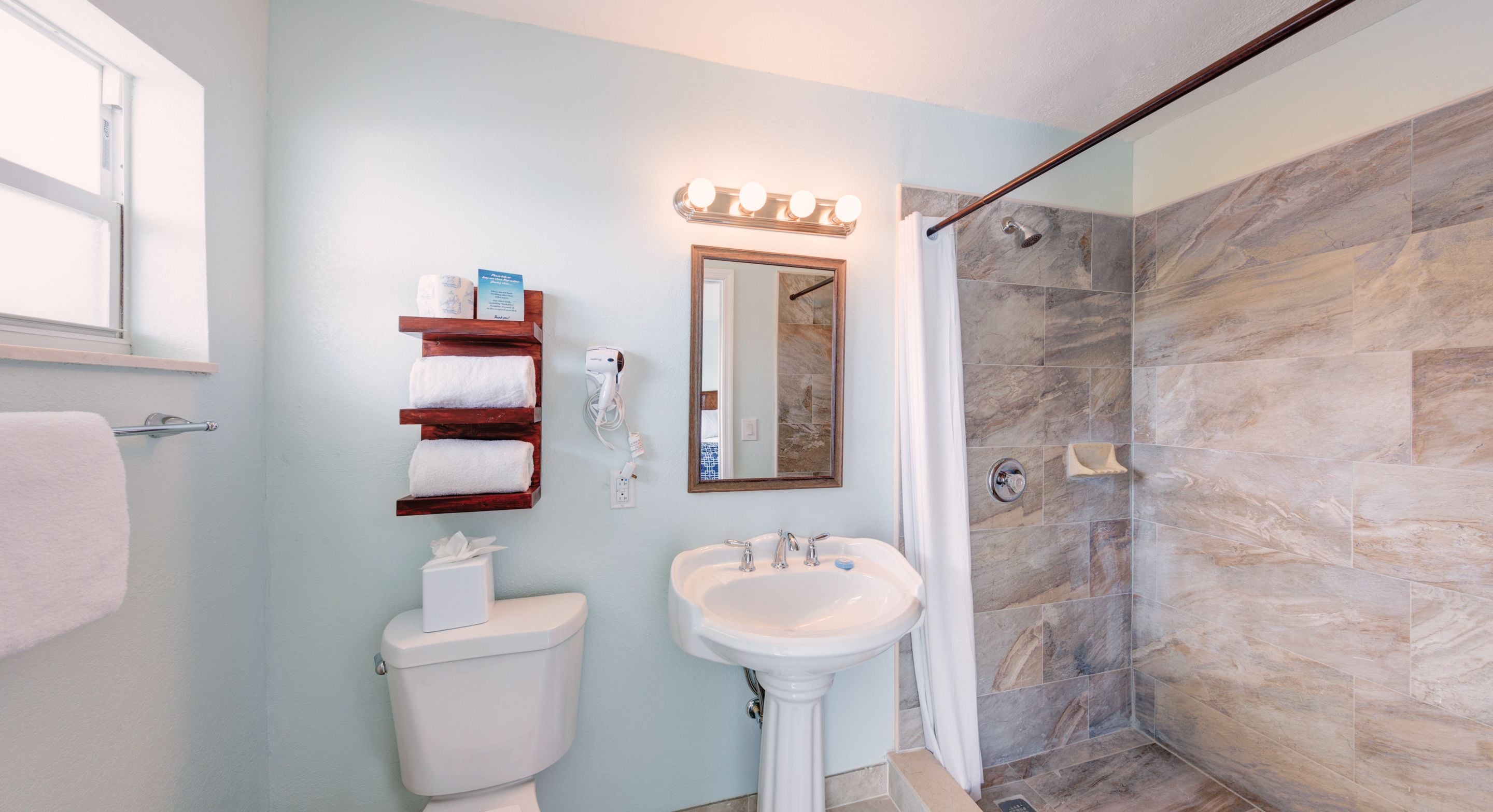 Un baño con inodoro, lavamanos y ducha.
