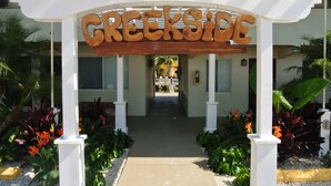 A wooden sign with the name 'Creekside' above a white pergola entrance. - Creekside Inn (Tavernier)