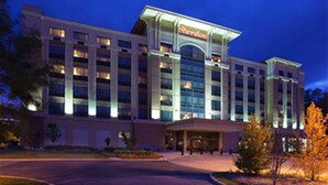 Un hotel Sheraton con fachada moderna, varios pisos y una entrada destacada.