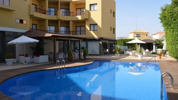 Una piscina al aire libre de temporada, sillones reclinables de piscina