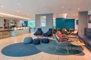 A modern lounge area with seating, a bar, and a view of the outdoors. - Four Points Flex by Sheraton Doncaster (Doncaster)