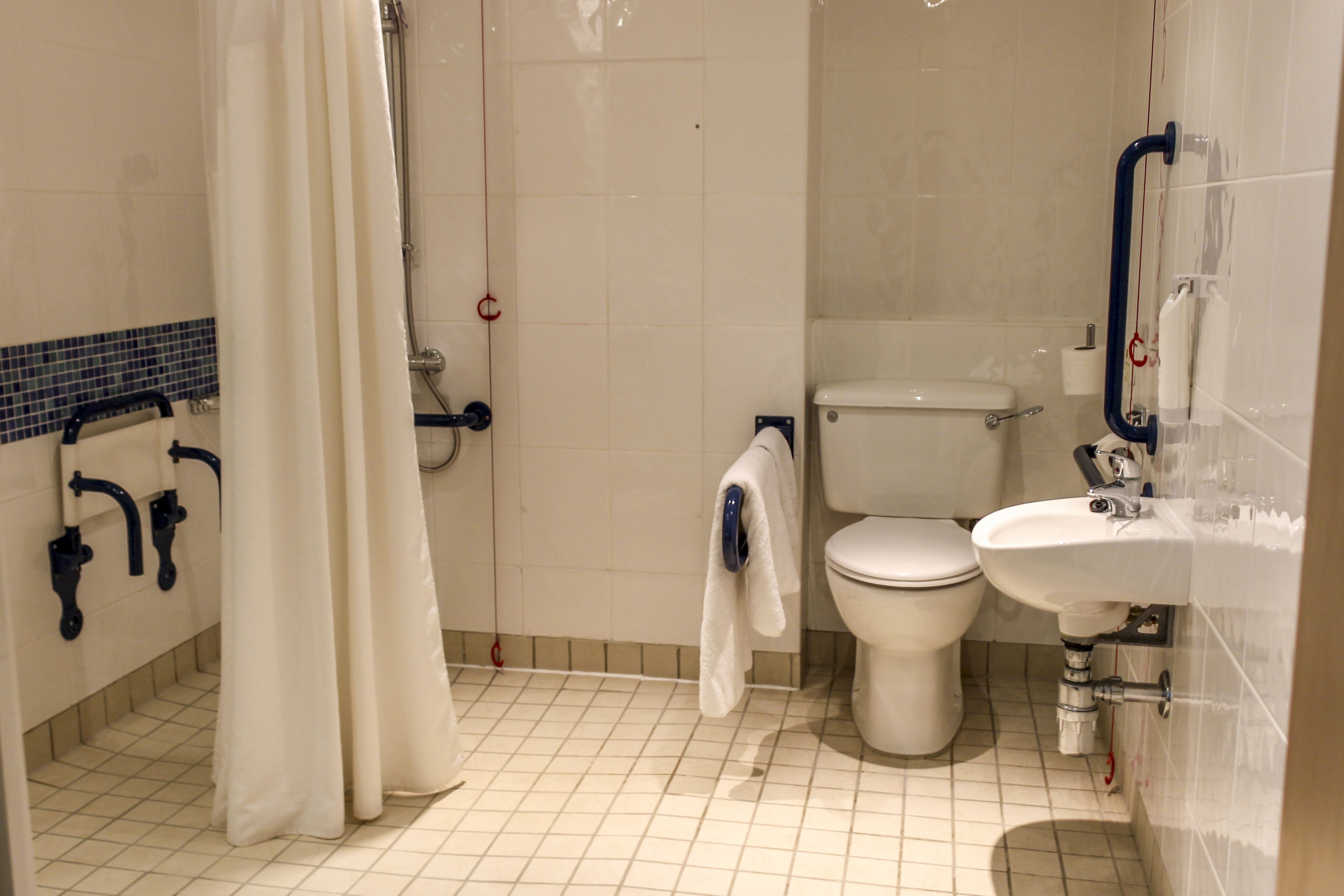 A bathroom with a toilet, sink, and shower area.