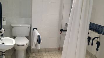 A bathroom with a toilet, sink, and shower area.