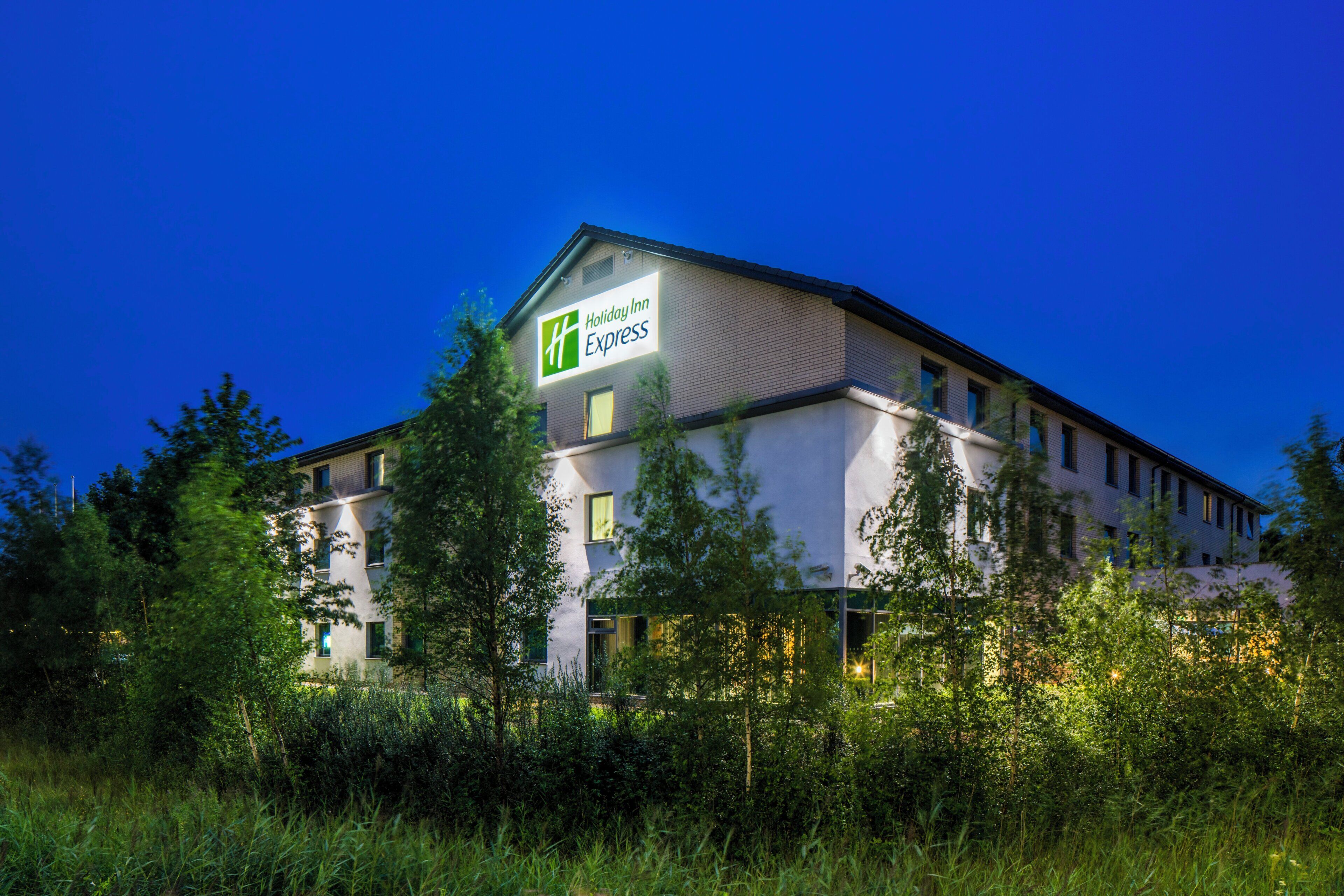 Un hôtel Holiday Inn Express au design moderne, entouré de verdure.