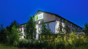 Un hôtel Holiday Inn Express au design moderne, entouré de verdure.