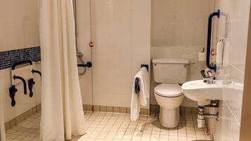 A bathroom with a toilet, sink, and shower area.
