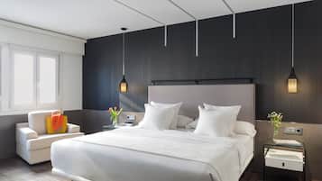 Una moderna camera d'hotel con un letto grande, comodini, una sedia e una finestra.
