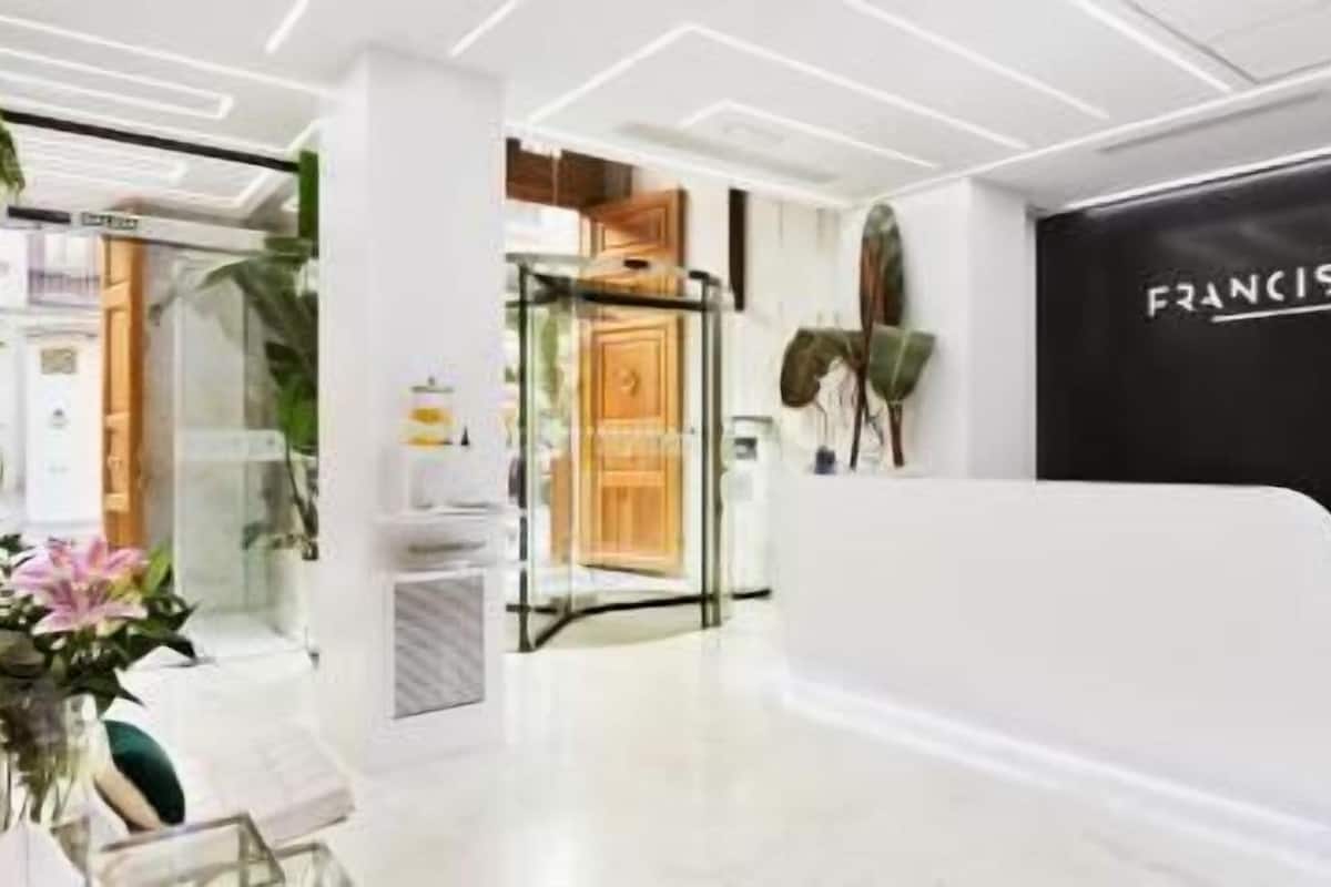 A modern reception desk with a black backdrop and the name 'FRANCISCO' in white letters.