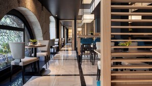 A modern hotel lobby with a marble floor, seating areas, and a staircase. - Hotel Francisco I (Madrid)