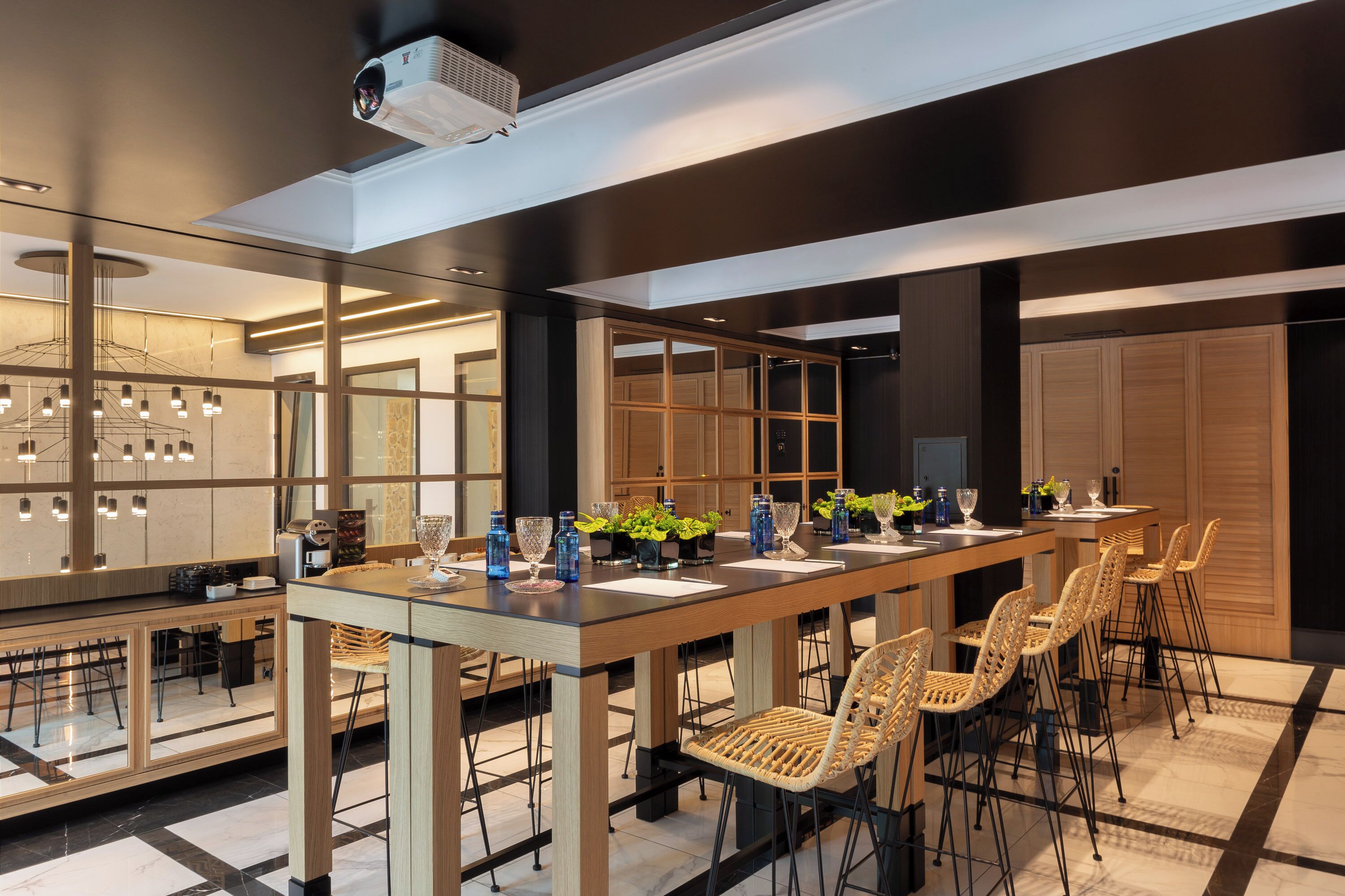 A modern conference room with a long table, chairs, and a projector.