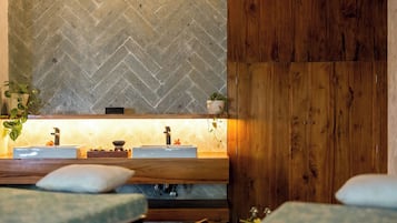 A bathroom with a herringbone tile wall, wooden paneling, and a sink with a mirror.