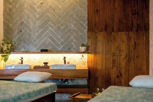 A bathroom with a herringbone tile wall, wooden paneling, and a sink with a mirror.