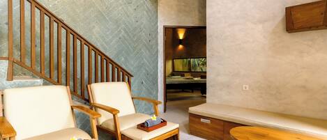 A spa-like area with wooden chairs, a bench, and a stone wall.