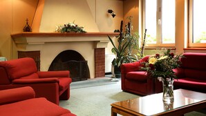 A living room with red sofas, a fireplace, and a large window.