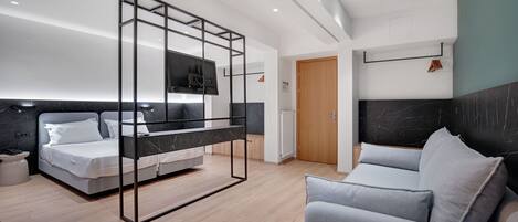 Une chambre d’hôtel moderne équipée d’un lit, d’un canapé, d’une télévision et d’une porte en bois.