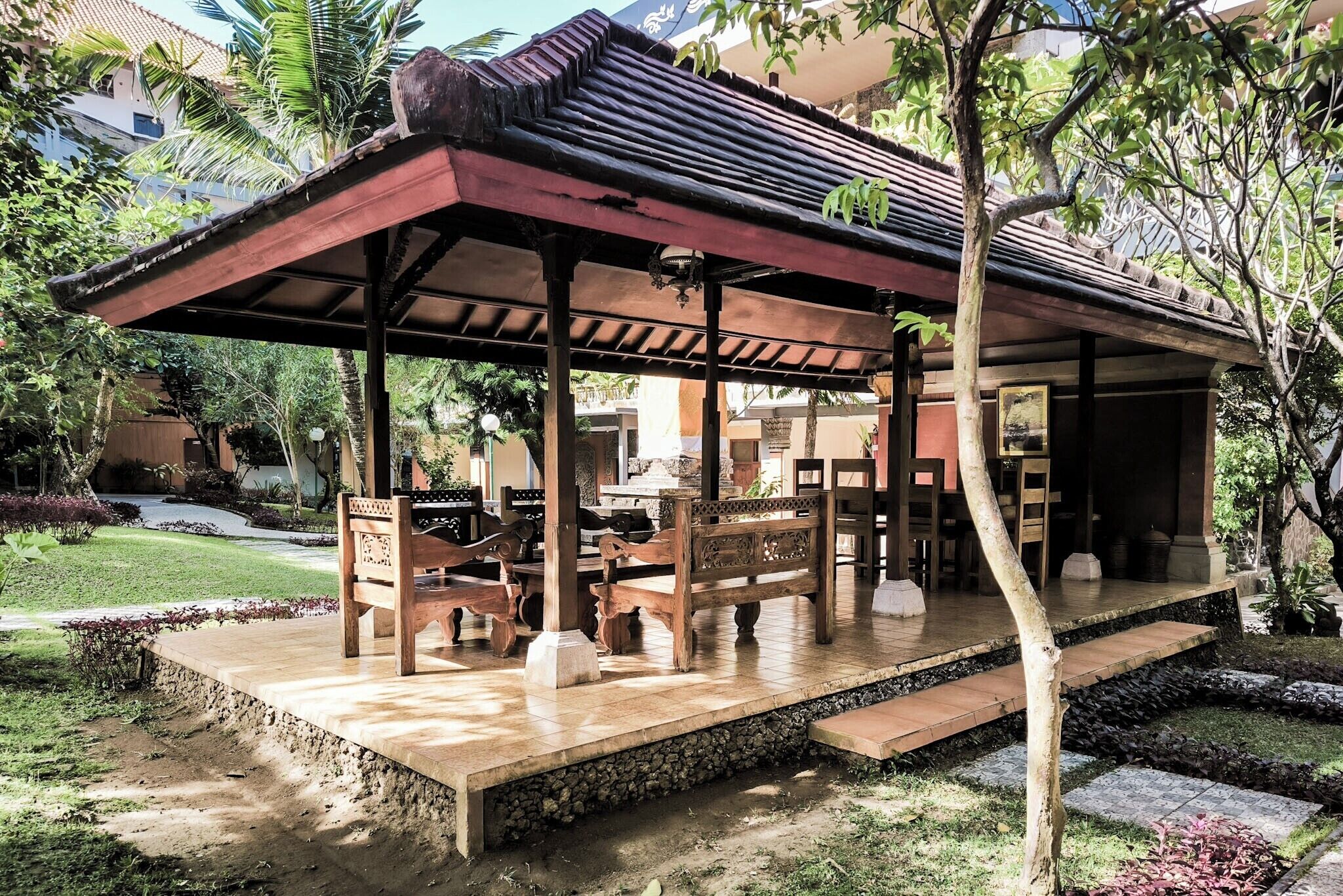 A covered outdoor seating area with benches and a pergola structure.