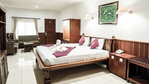 A hotel room with a bed, bedside table, wardrobe, and a desk with a telephone. -  Melasti Kuta Beach Hotel and Spa (Kuta)