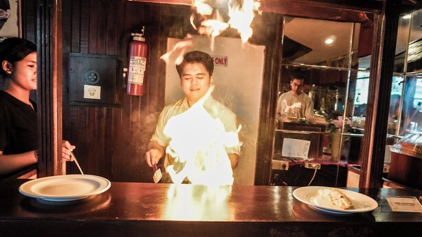 A restaurant interior with a counter, a fire extinguisher, and a person behind the counter. -  Melasti Kuta Beach Hotel and Spa (Kuta)