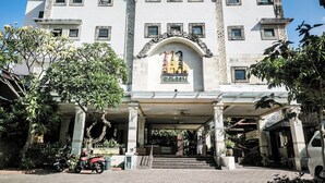 A multi-story hotel with a central entrance, columns, and a signboard. -  Melasti Kuta Beach Hotel and Spa (Kuta)