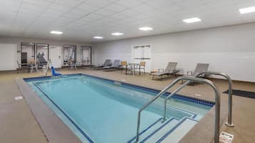 Una piscina con sillas de descanso y un puesto de socorristas.