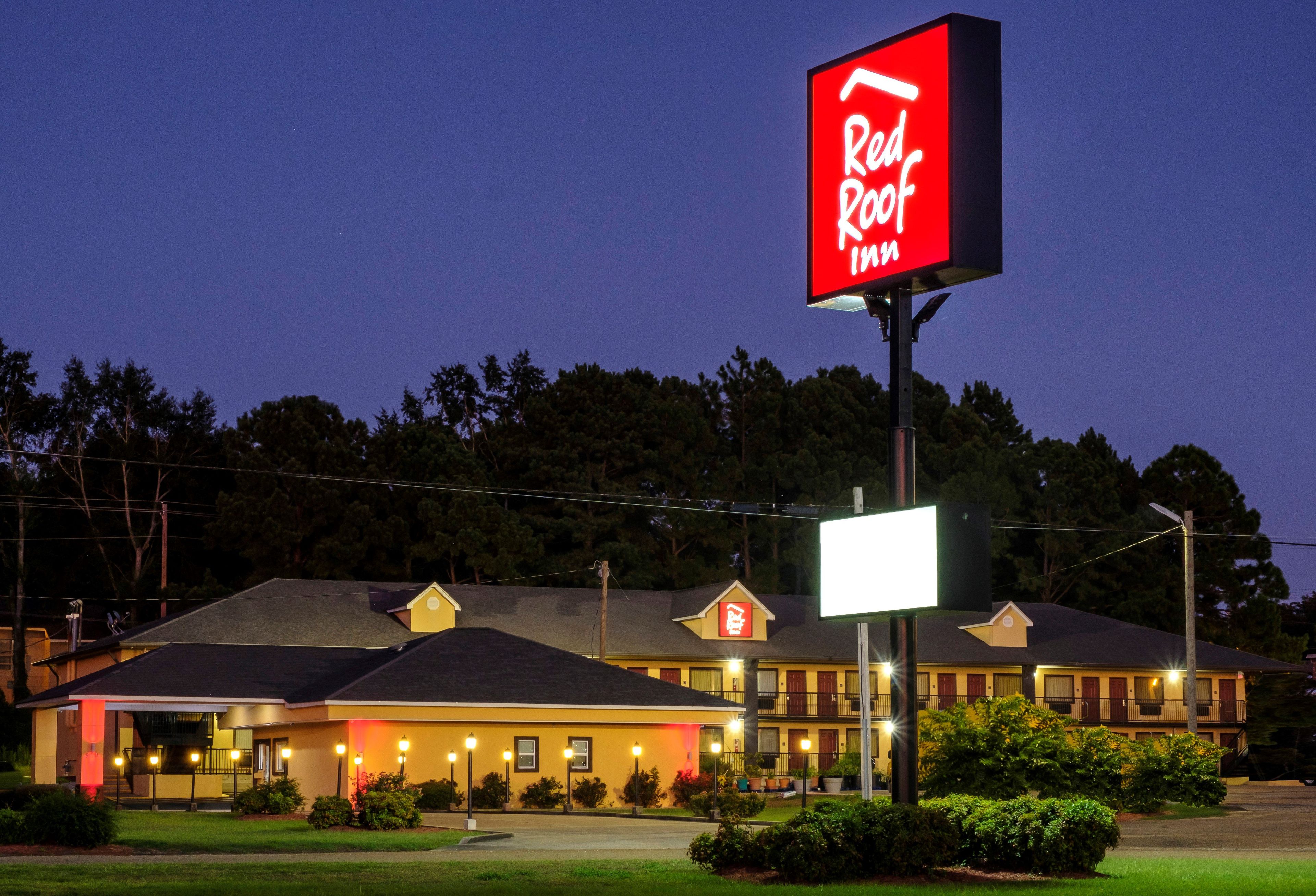 A Red Roof Inn with a large illuminated sign, a two-story building, and a parking lot.