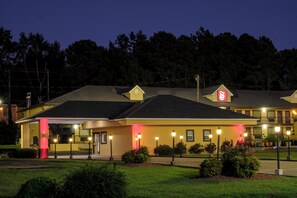 A hotel with a two-story structure, a parking lot, and a well-maintained lawn. - Red Roof Inn Columbus, MS (Columbus)