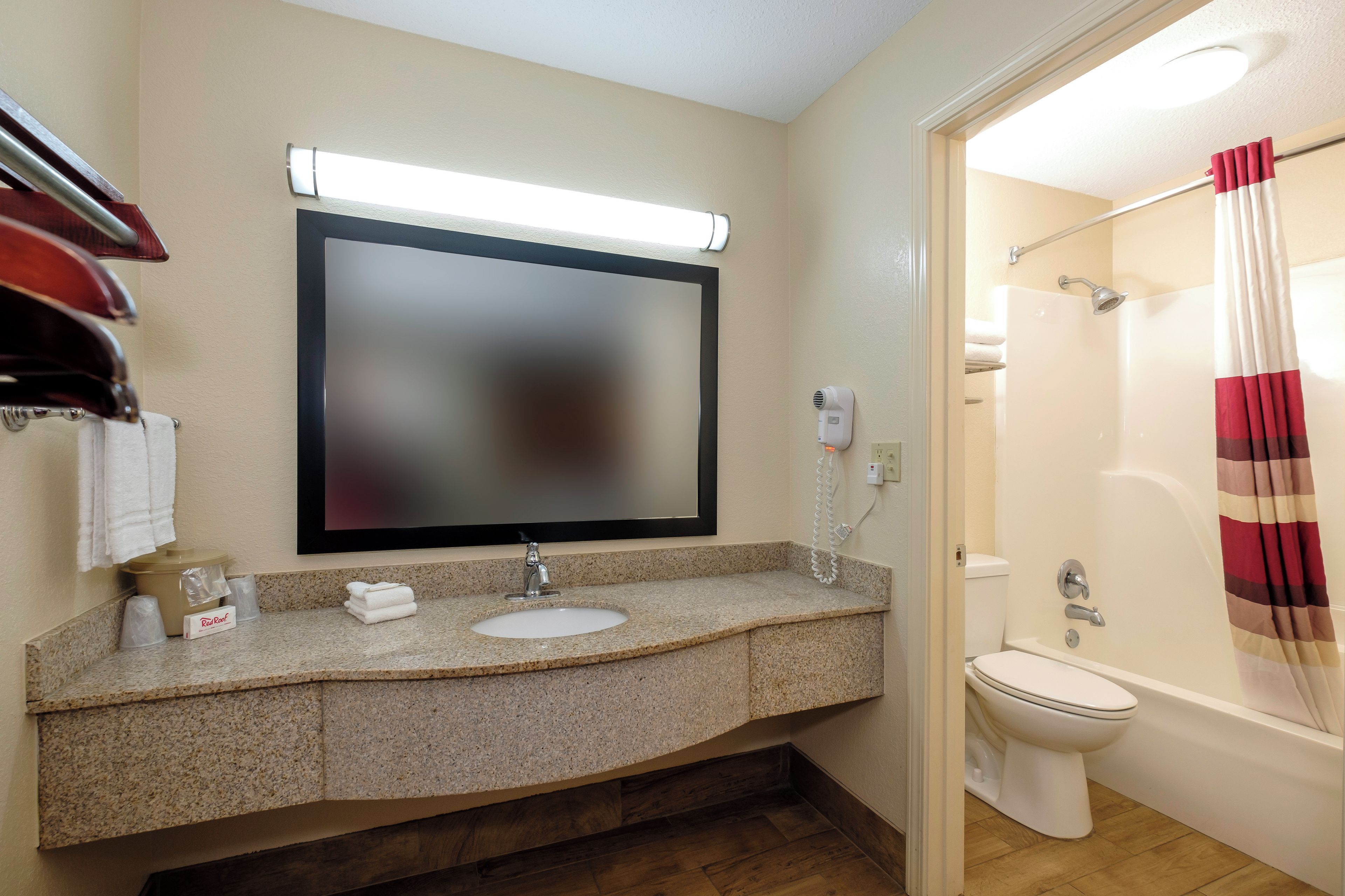A bathroom with a sink, mirror, toilet, and shower.