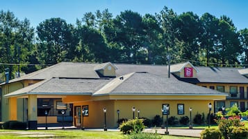 A two-story motel with a flat roof, a visible entrance, and a sign indicating it is a Red Roof Inn.