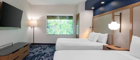 Habitación de hotel con dos camas, televisión, lámpara y un ventanal con vistas a árboles.