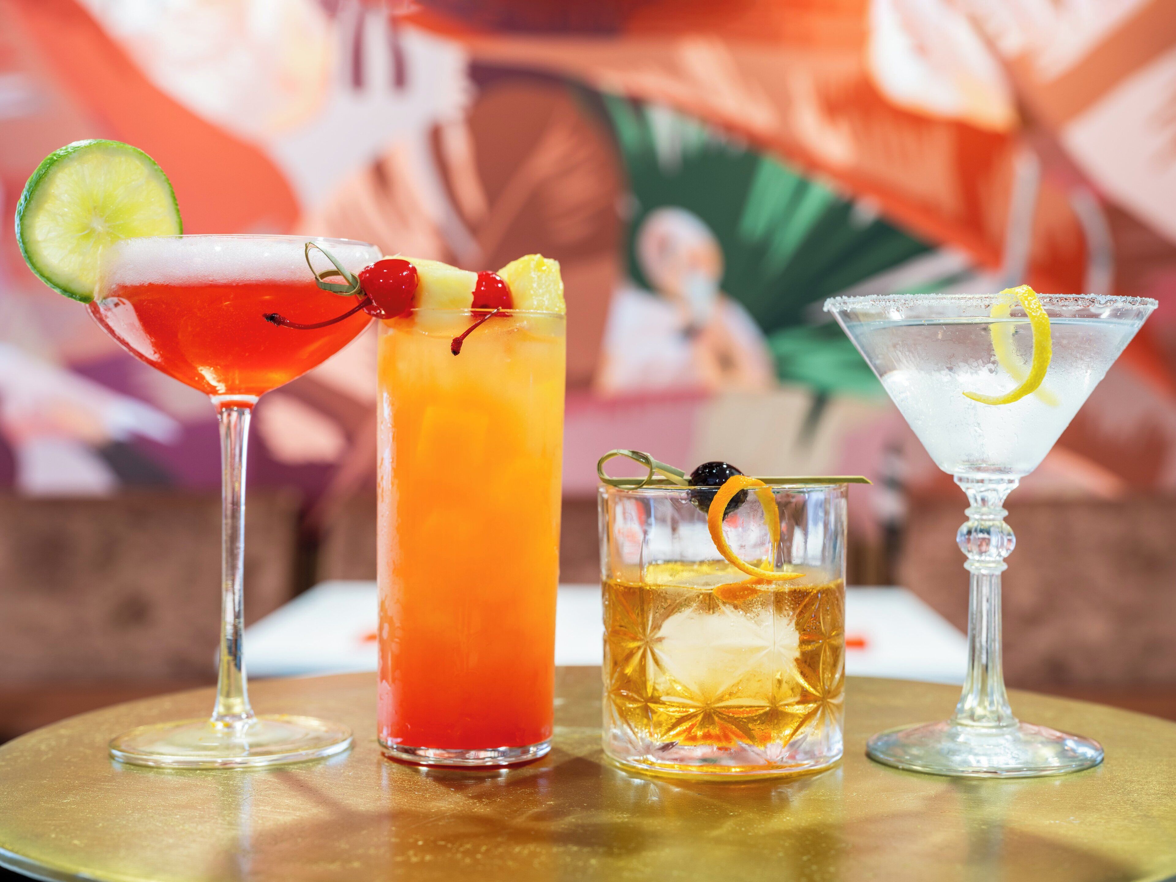 Three different cocktails on a table with a blurred background.
