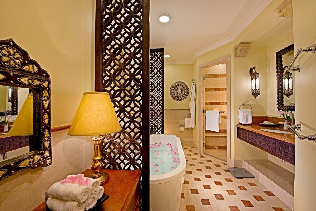 A bathroom with a bathtub, a sink, and a mirror.