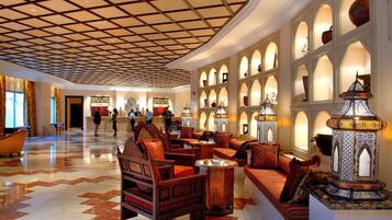 A lobby with a checkered ceiling, patterned floor, and traditional furnishings.