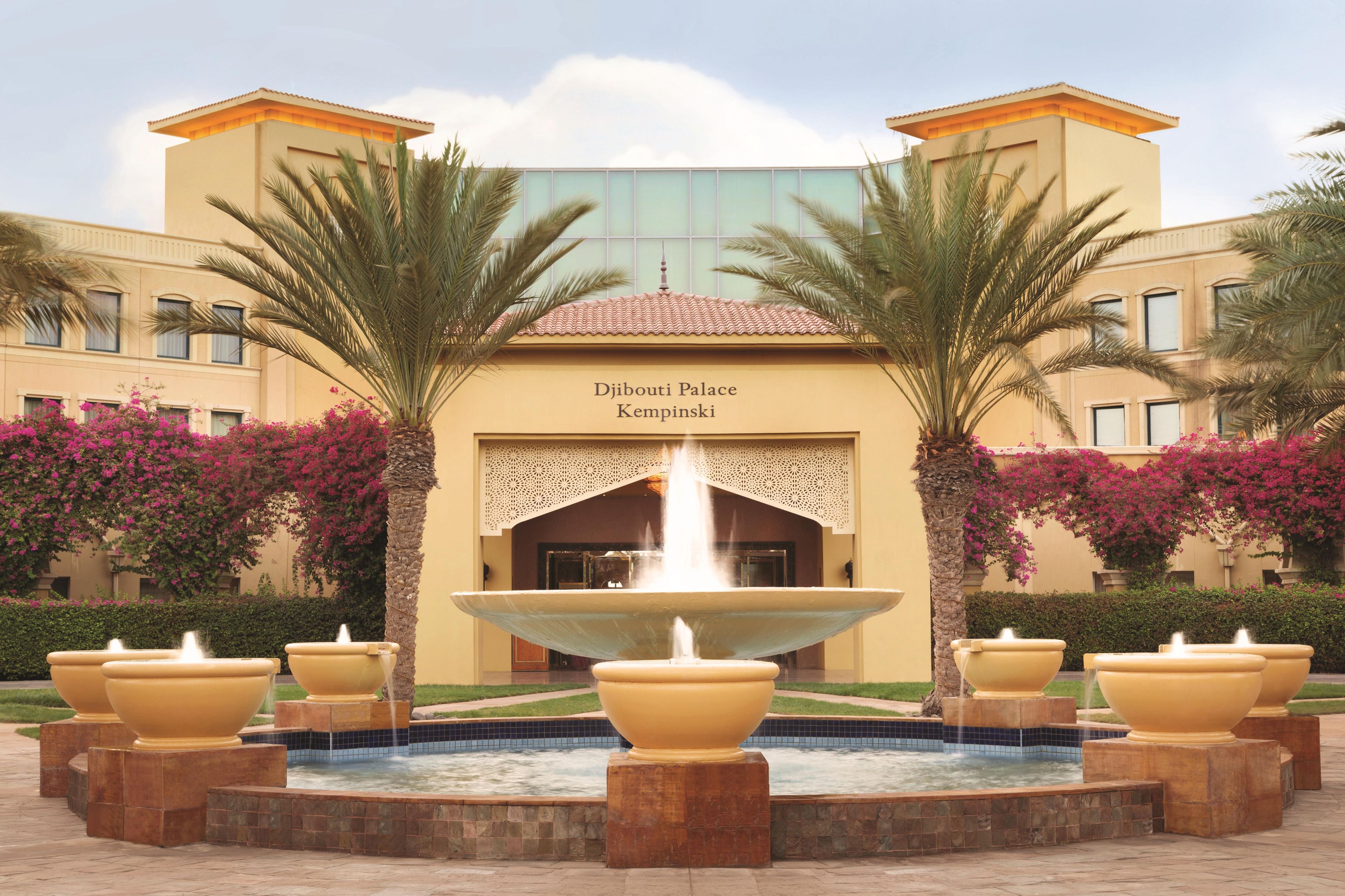 Djibouti Palace Kempinski with a central fountain and palm trees.