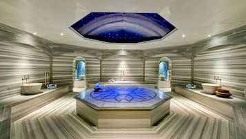 A luxurious bathroom with a central circular sink, two large arched windows, and a ceiling with a starry sky design.