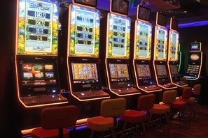 A row of slot machines with a display screen, control panel, and a cash dispenser. - Djibouti Palace Kempinski (Djibouti)