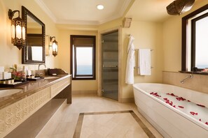A bathroom with a large bathtub, a double sink vanity, and a glass shower enclosure. - Djibouti Palace Kempinski (Djibouti)