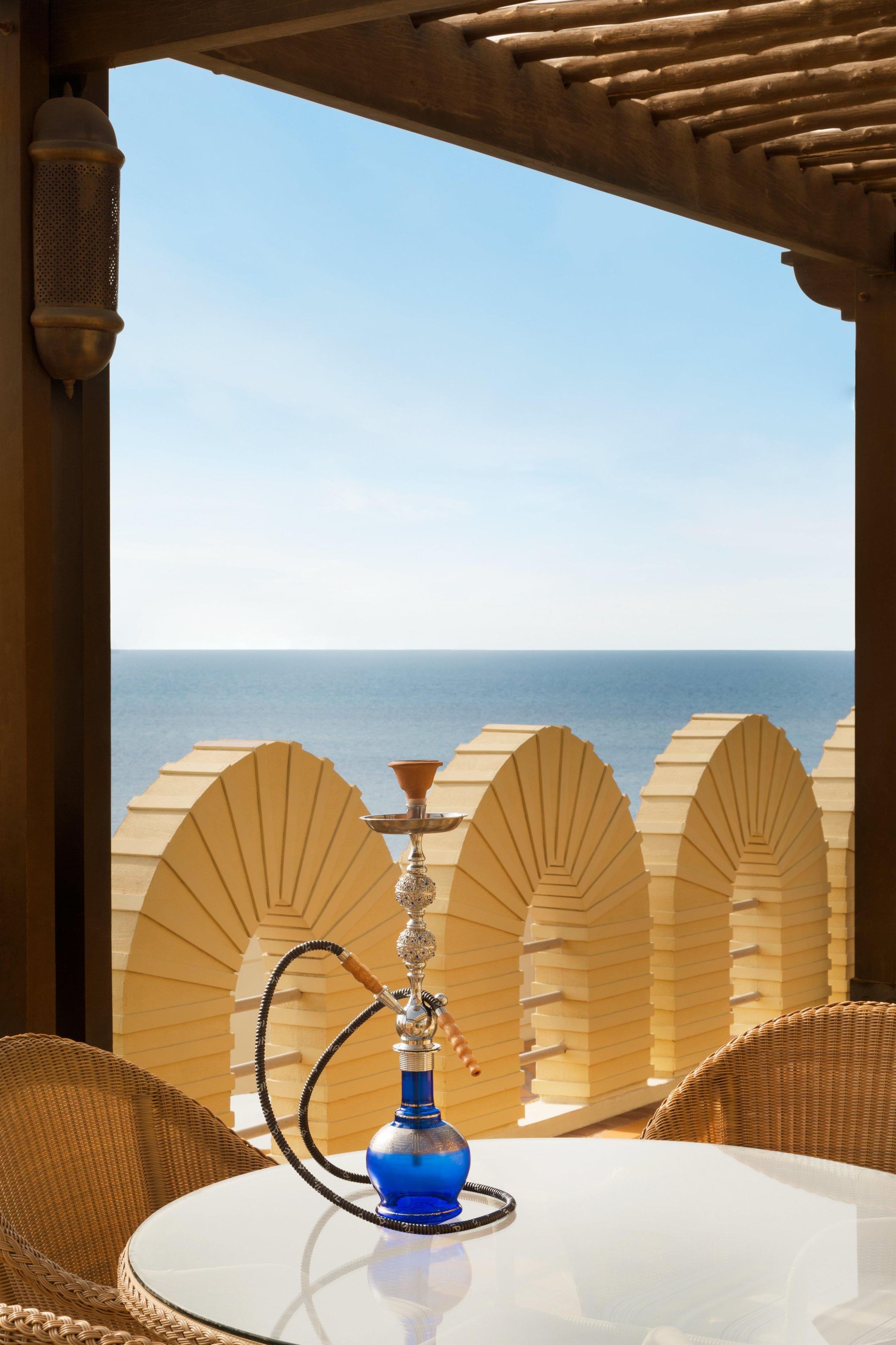 A hookah on a table with a view of the sea.